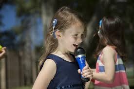 Smiling girl singing into microphone