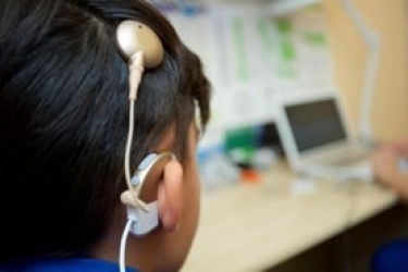 Speaking exercise with a woman coaching a young male wearing earphones speaking into a microphone