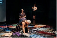 Actors on a stage filled with textiles