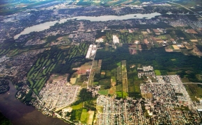 Aerial view of the City of Laval, with houses and roads, the river in the background, and about 20% green cover
