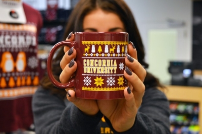 A mug with the words Concordia University and a sweater design