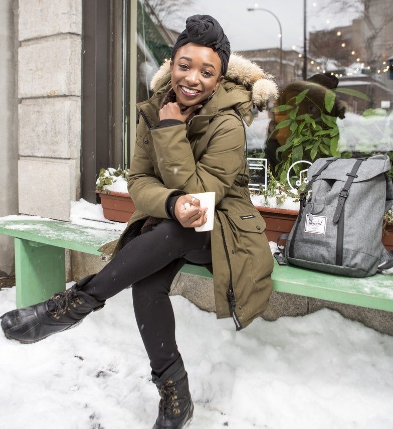A smiling young woman takes a coffee break outside a café A smiling young woman takes a coffee break outside a café