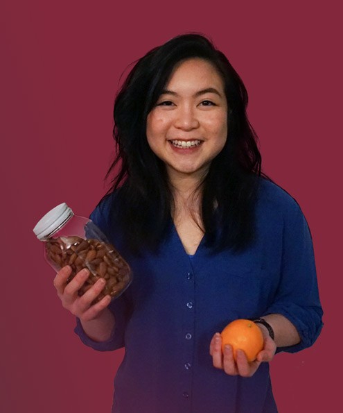 Dietitian Jessy Cheung holds a bottle of almonds and an orange