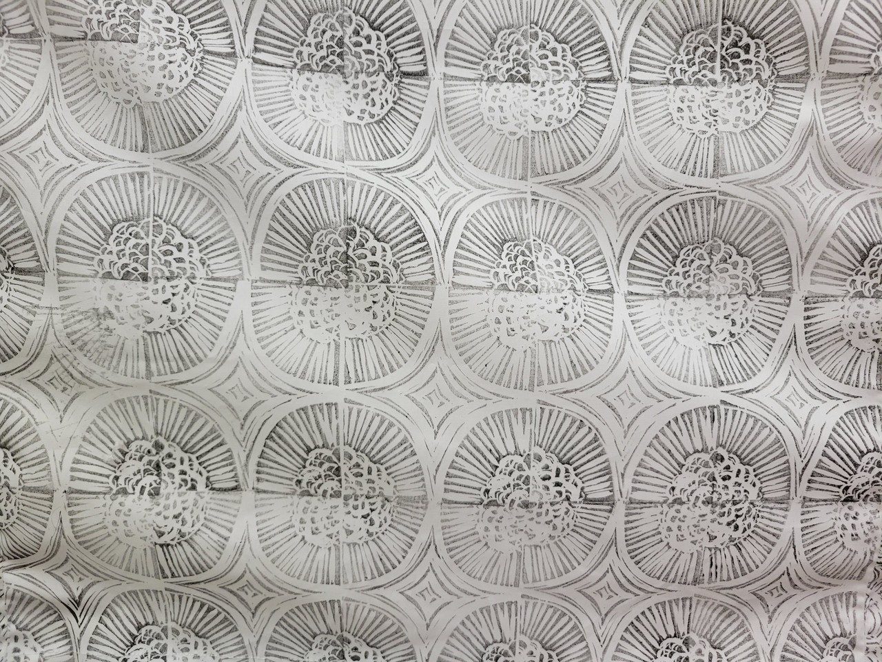 close up capture of a large black and white bloc printing on textile with repetitive and abstract motif inspired by organic forms