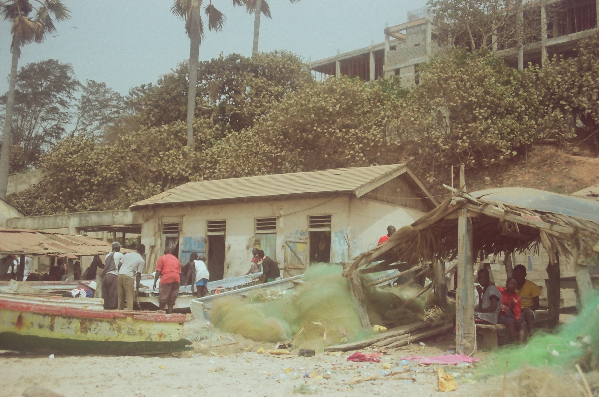 Still from a scene where people are gathered around fishing boats and nets
