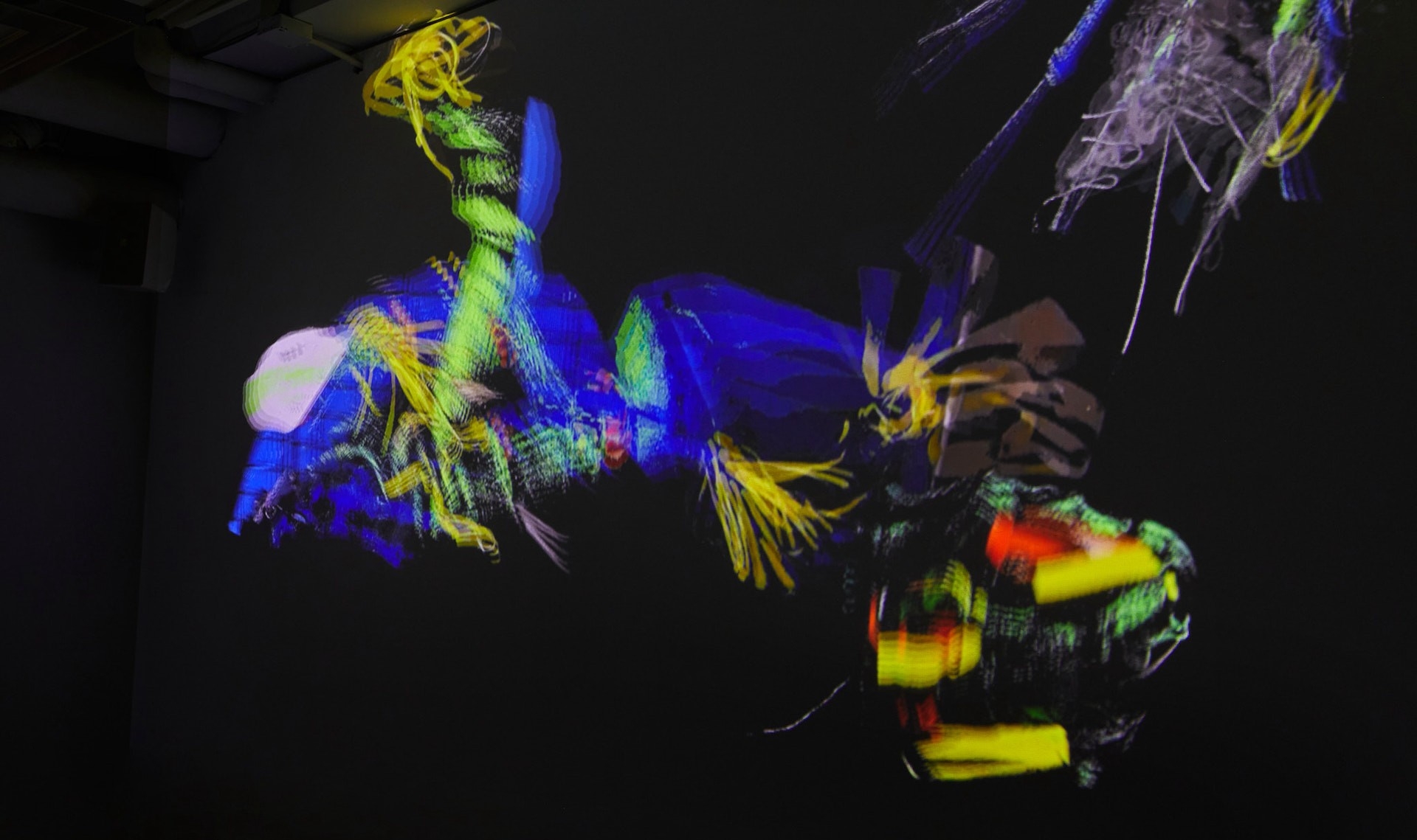 Projections onto a ceiling and walls of colourful amorphous limbs