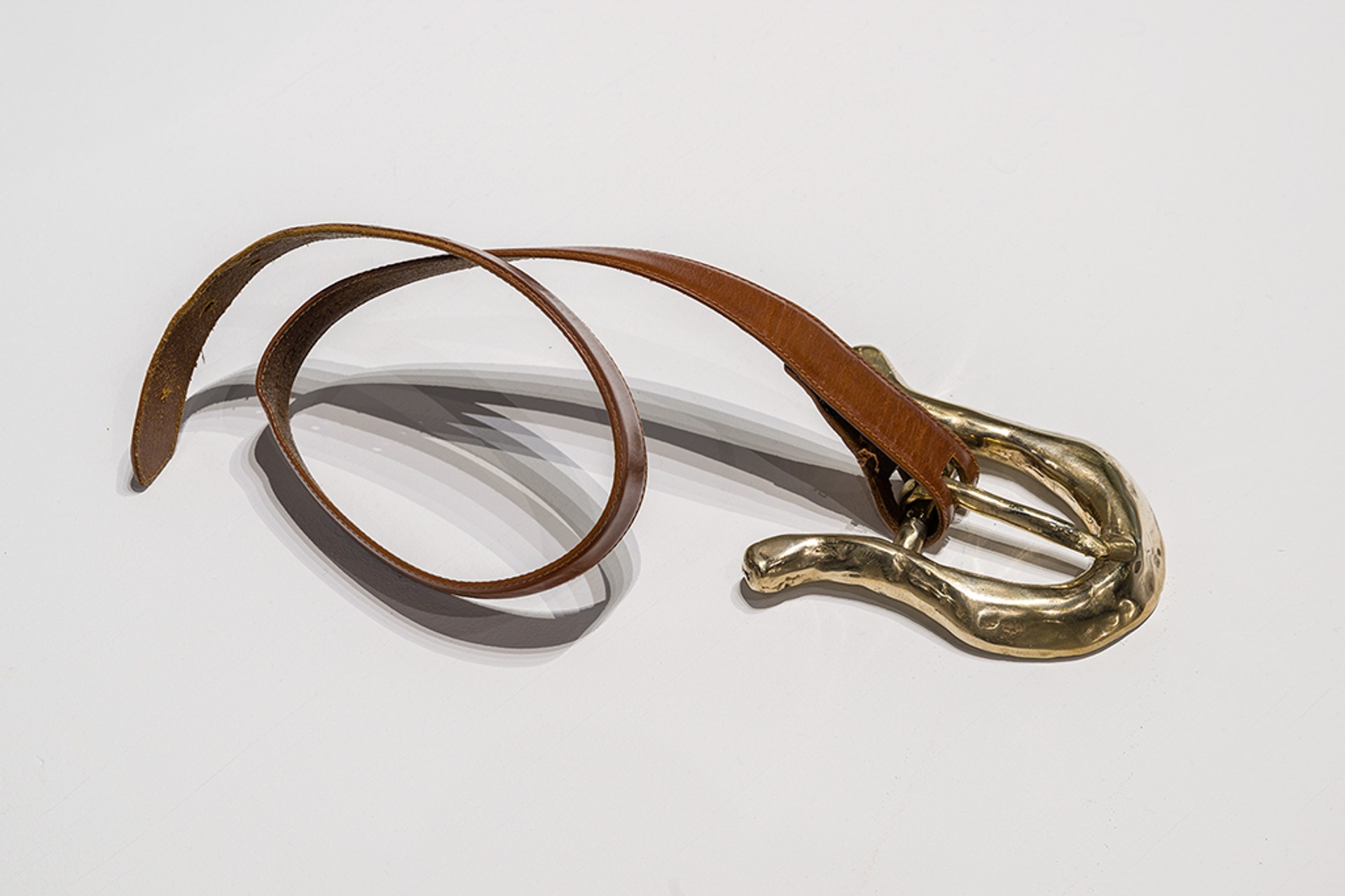 close-up photograph of a belt with an oversized metal buckle.