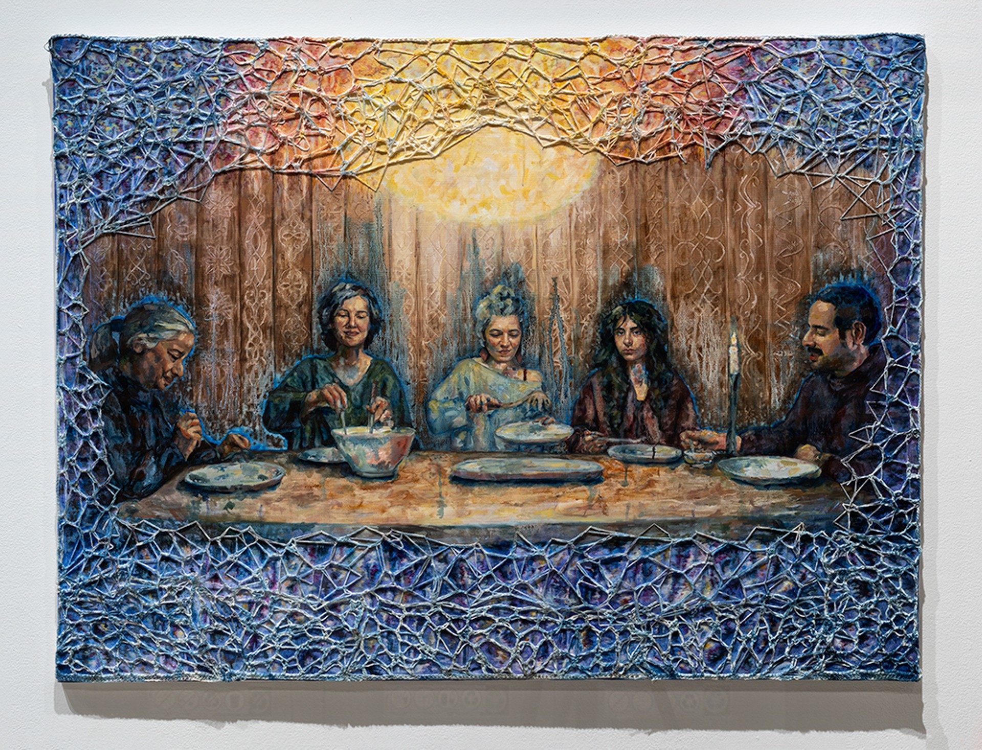 Painting of five people having dinner on a round table; they are surrounded by a textile web of blue and yellow yarn and a bright yellow sun illuminates them from above 