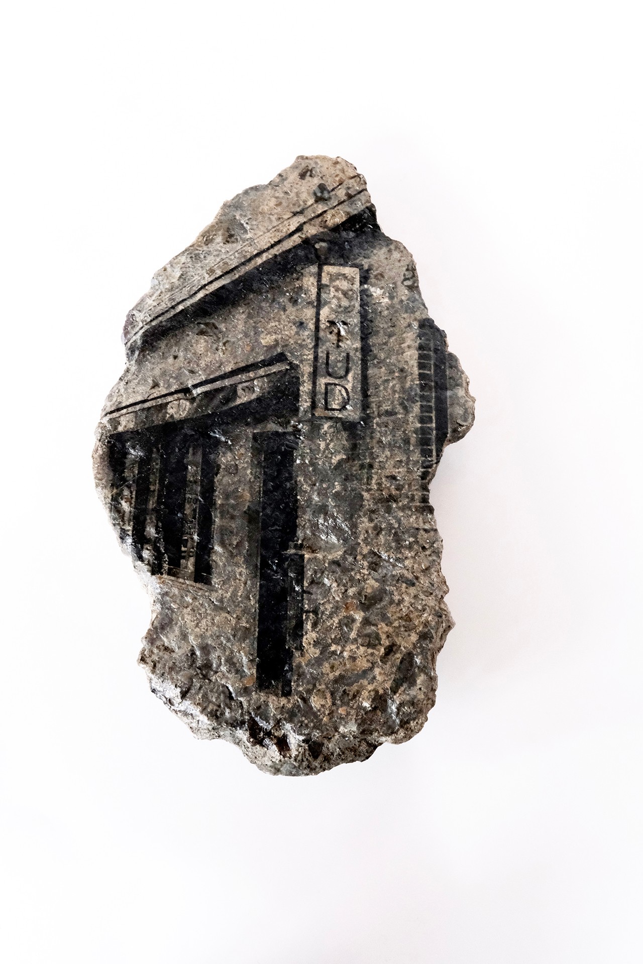 Rocher avec l'image d'une salle avec un panneau où l'on peut lire le mot Stud. L'image transférée sur le rocher est en noir et blanc.