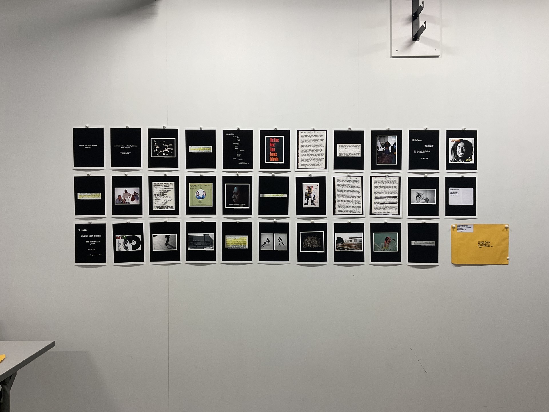Image détaillée des archives sur le mur. Les archives, principalement en noir et blanc, présentent de la littérature Noire et des portraits d'artistes connus.