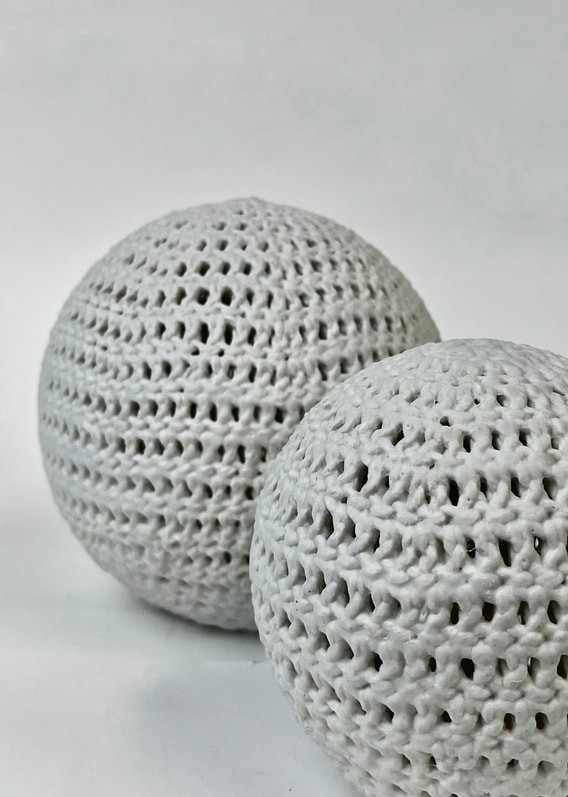 Gros plan sur un vase en porcelaine blanche dont la texture ressemble à du crochet.