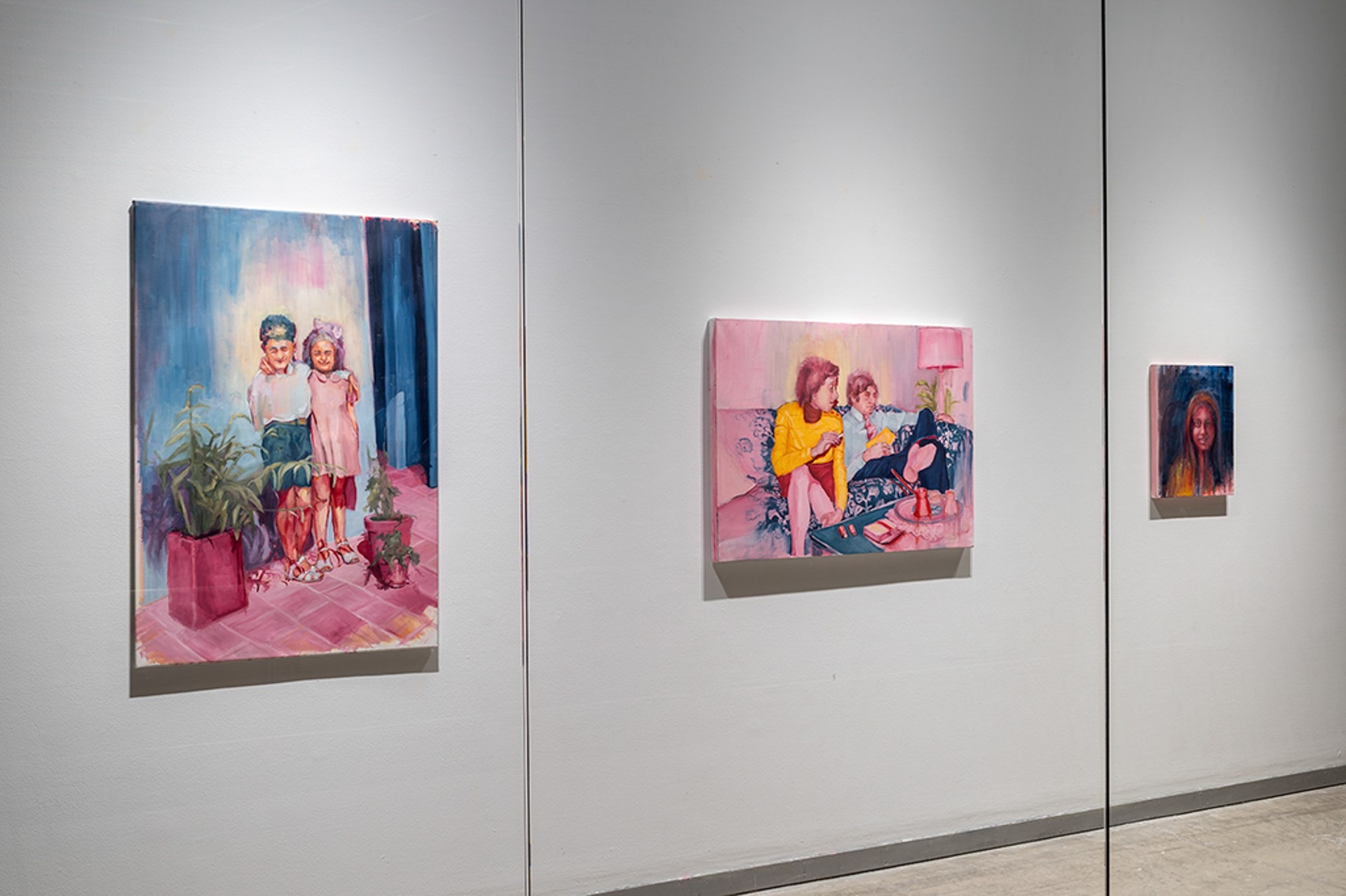 Vue d'une vitrine présentant trois tableaux accrochés au mur représentant des personnes sur des fonds colorés
