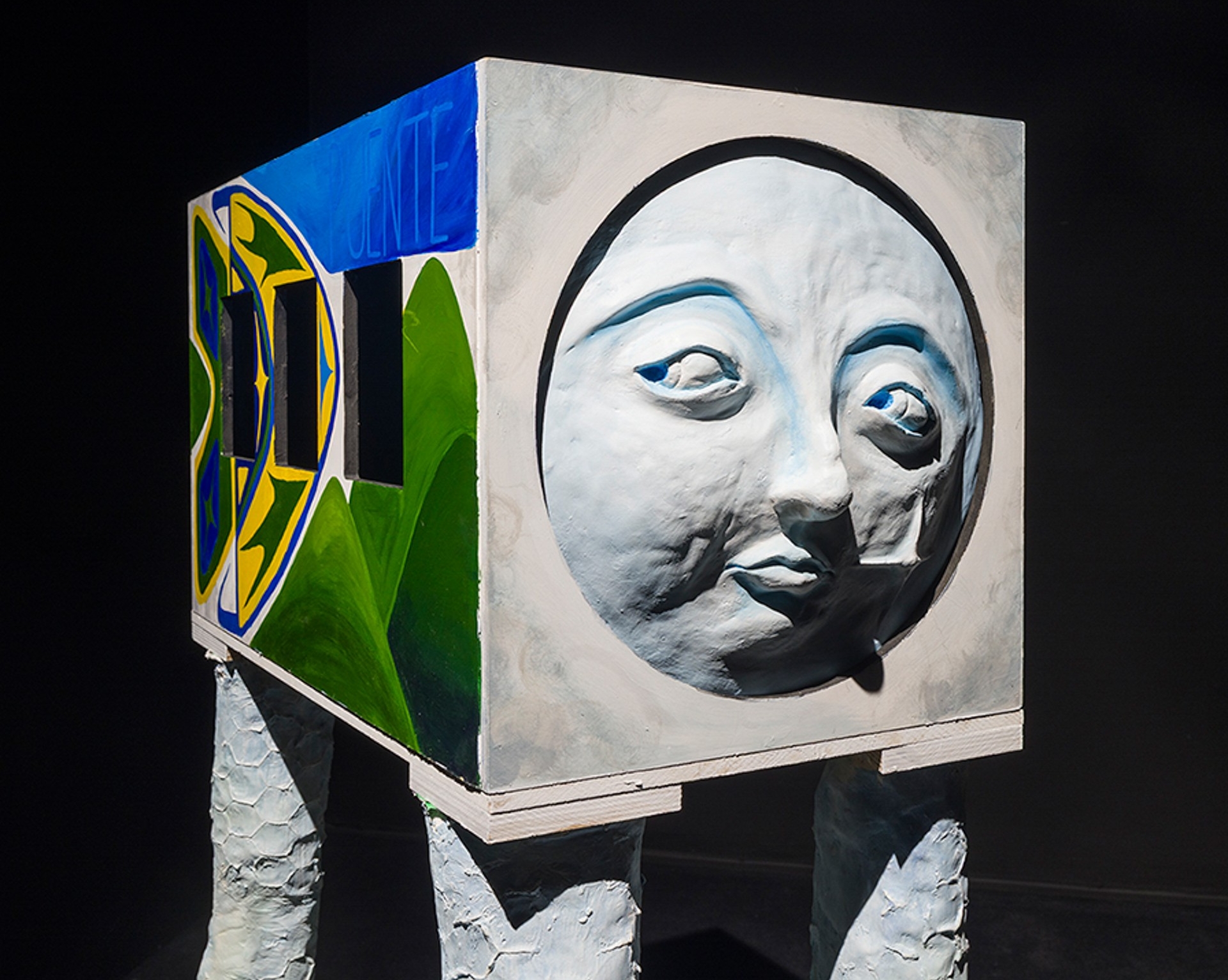 Une sculpture représentant un bus coloré avec de longues jambes blanches et un visage dubitatif.