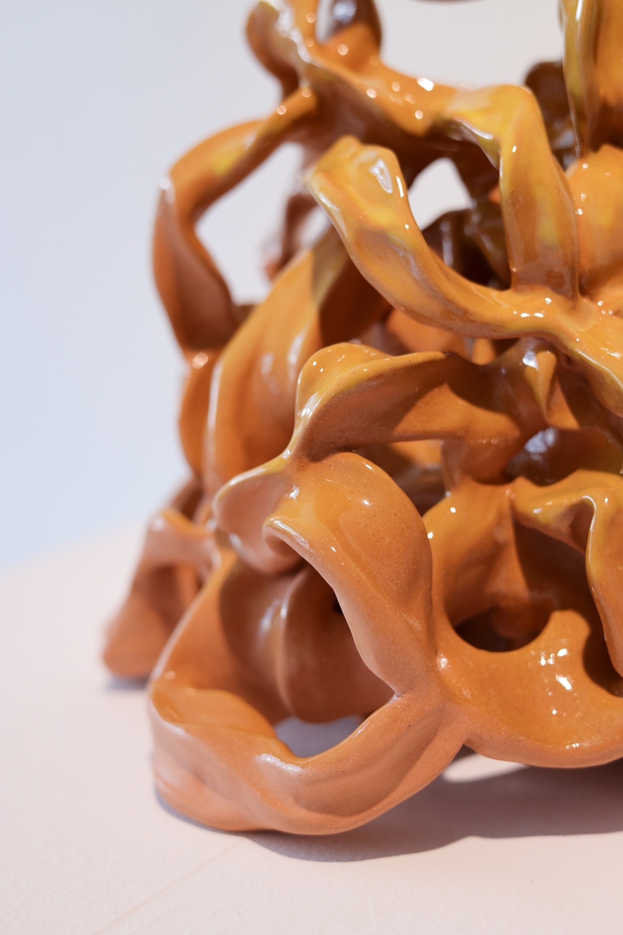 Gros plan sur une sculpture en céramique de rubans orange et jaune foncé