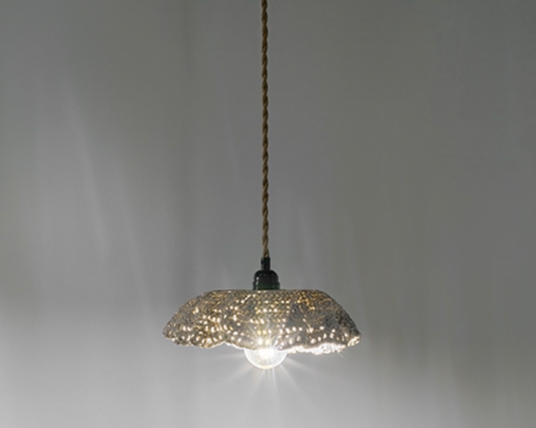 Une suspension dont l'abat-jour en porcelaine imite le crochet