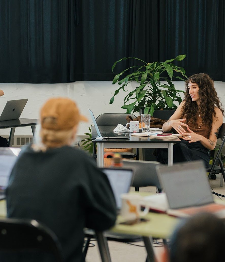 artists sitting with their computers in a workshop