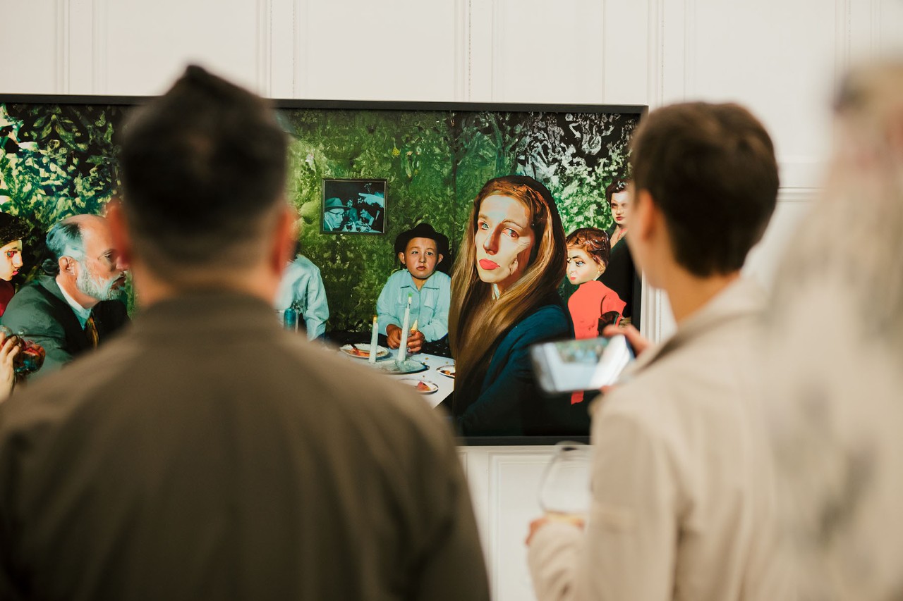Several people looking at a large digital photography in an art  exhibition