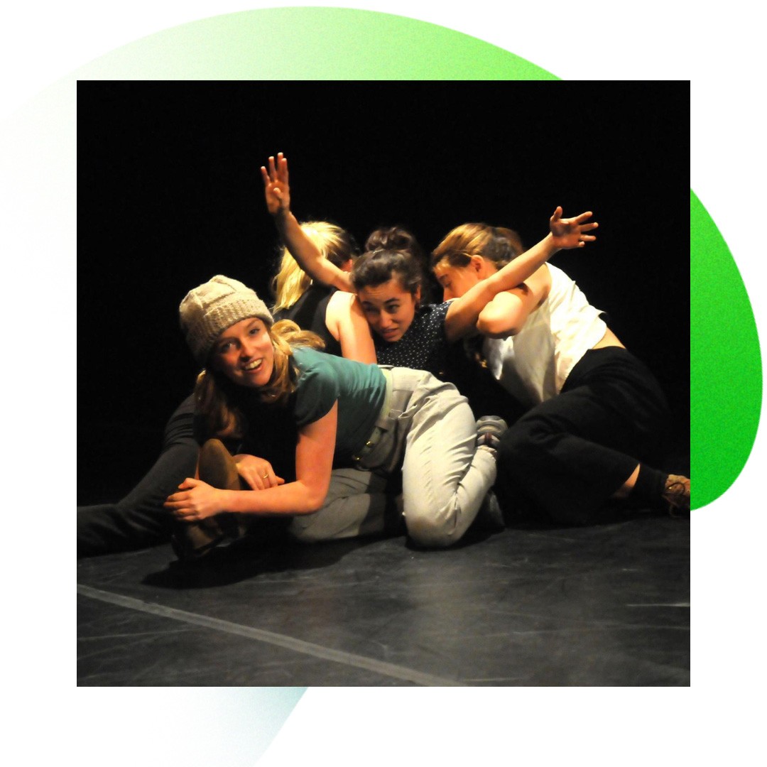 four dancers intertwined on the floor of a studio