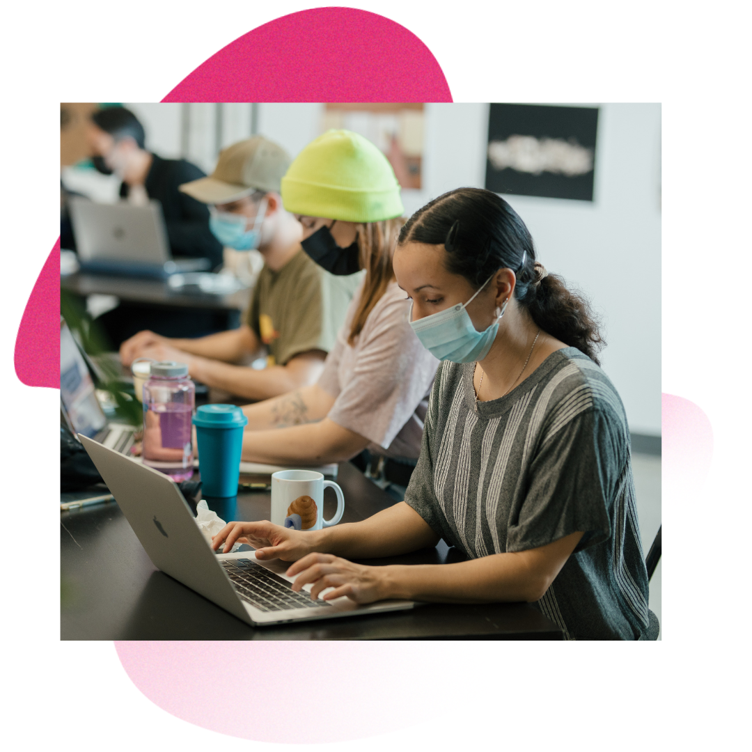 People sitting at a table and writing on computers