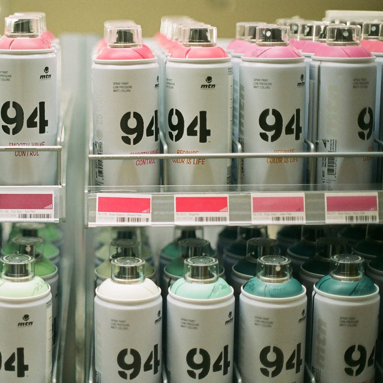 A display of spray paint cans for sale at a shop
