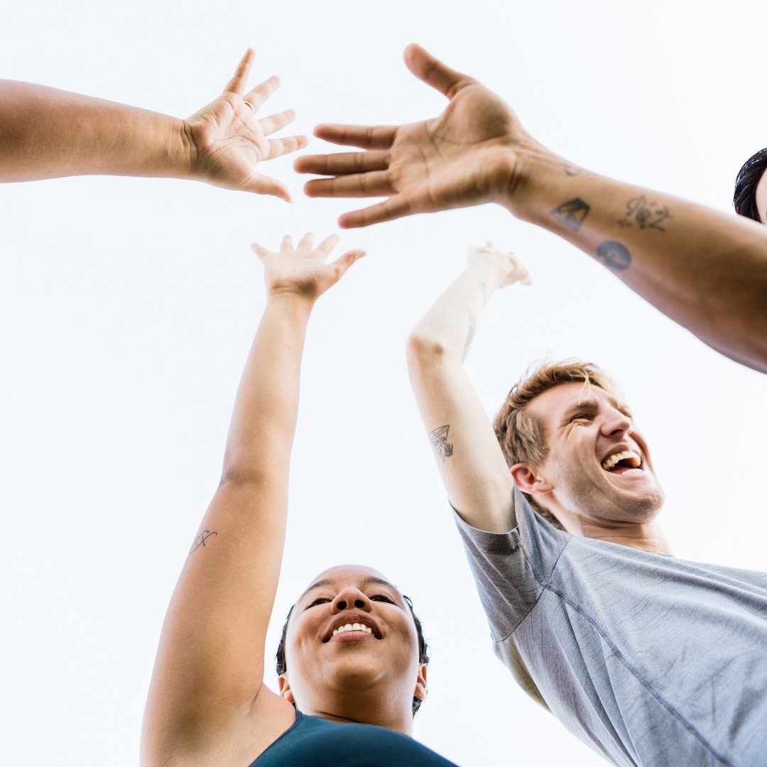 and image of a group of people putting their hands in a circle