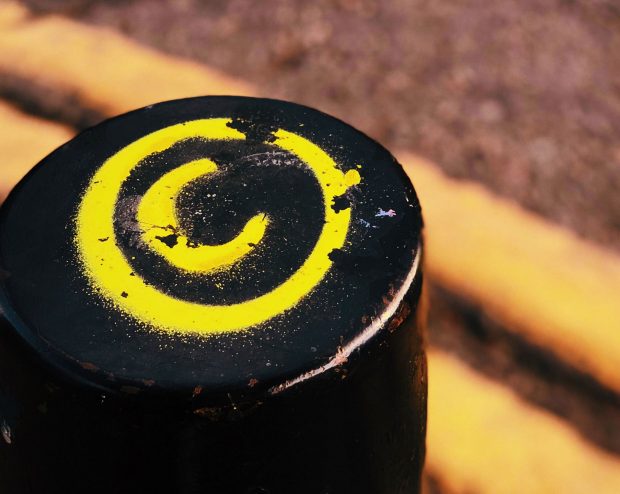 the copywrite symbol (the letter C with a circle around it) spray painted on a post on the street