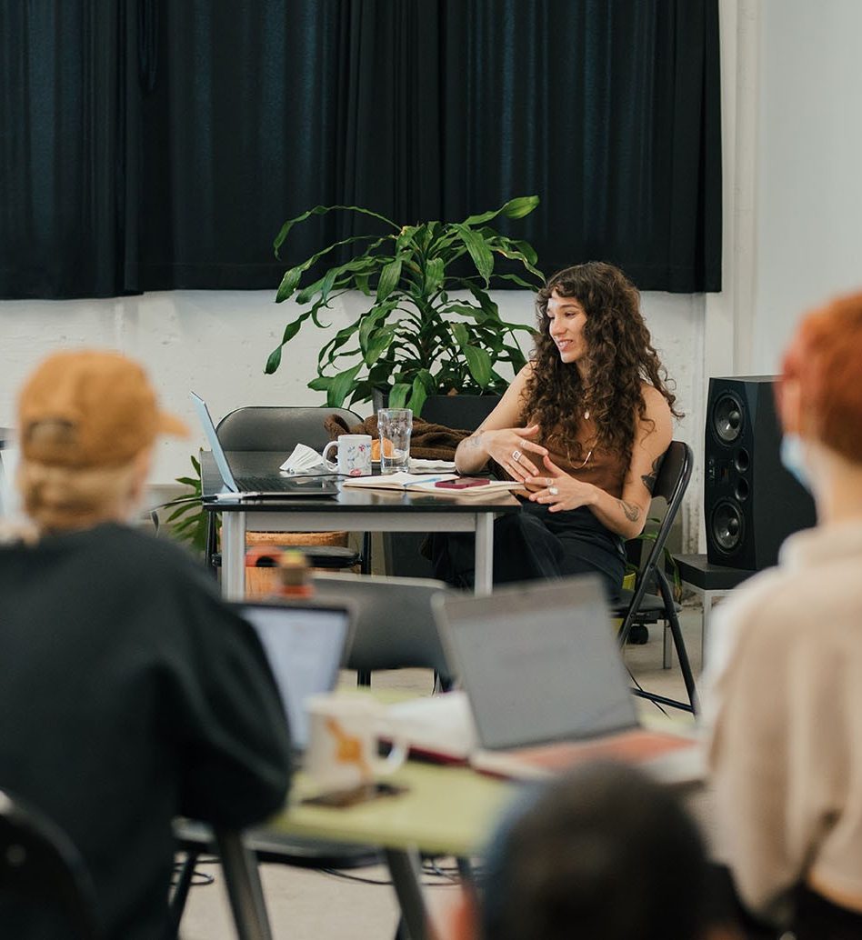 Une personne qui est assise devant un groupe et qui donne un atelier.