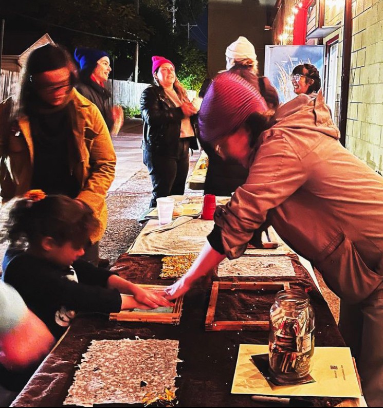 an artist leading an outdoor paper making workshop