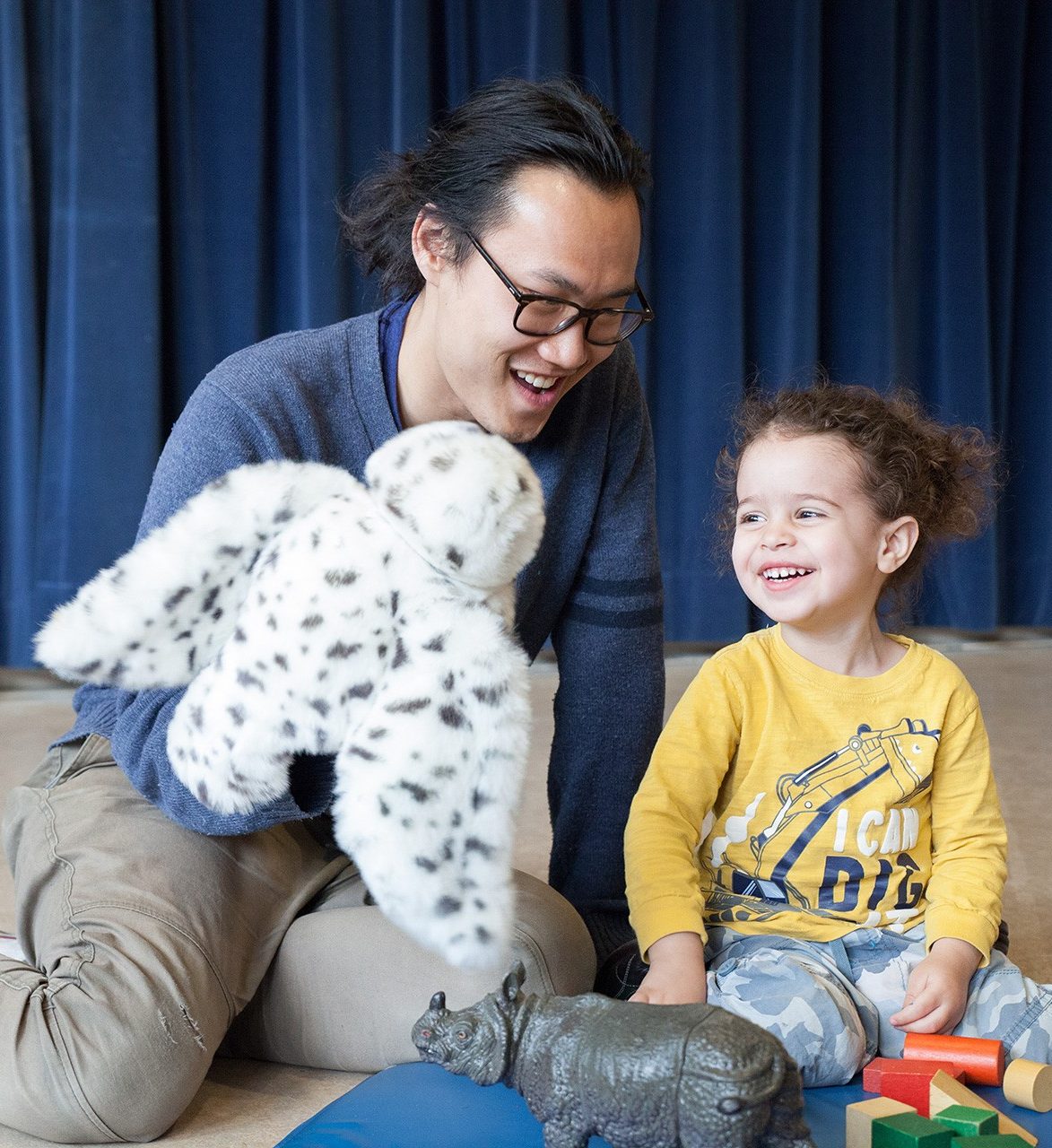 Creative Arts Therapies BIPOC male student uses a snowy owl puppet to interact with a young girl.