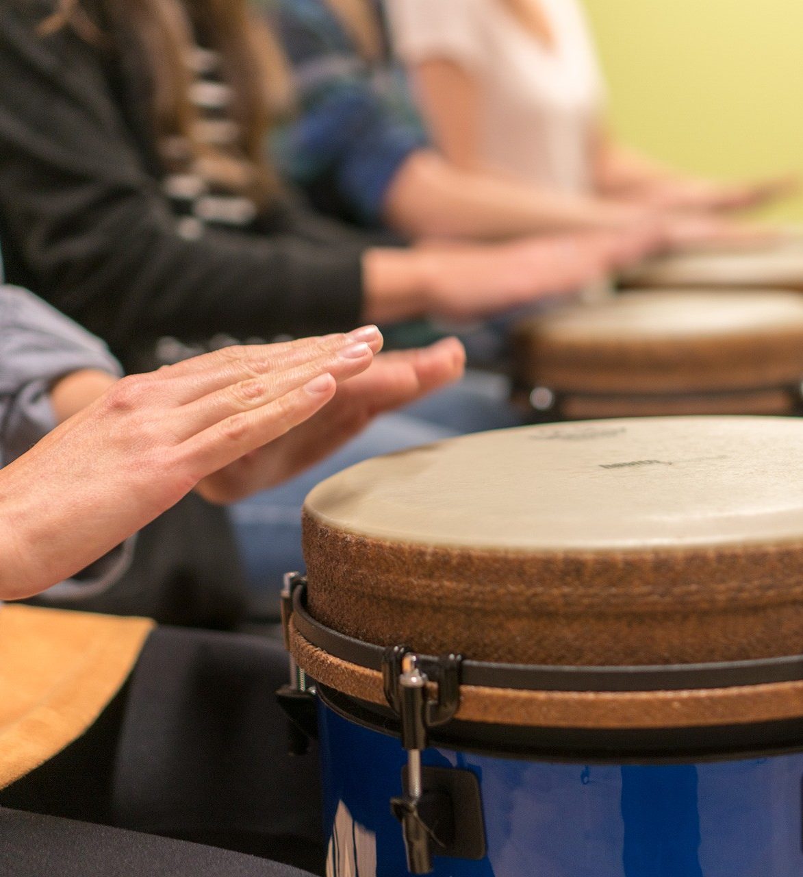 Creative Arts Therapies Close up of hands poised over a drum in the foreground.