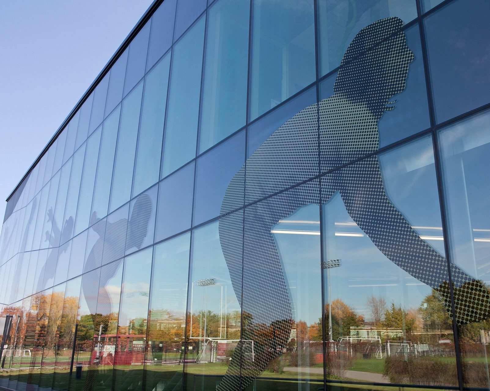 Exterior wall of PERFORM Centre decorated with figures of a person in the stages of making a jump. 