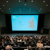 Theatre audience waiting for a film to begin. Concordia Film Festival logo appears on the screen.