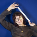 Kris Hodder smiling and holding a ruler