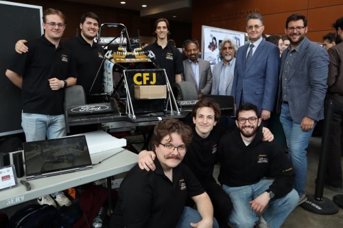 Group of Concordia SAE Formula Racing students with Dean Mourad Debbabi, Muthukumaran Packirisamy and Ashok Kaushal posing around a student-built race car at a capstone design showcase.