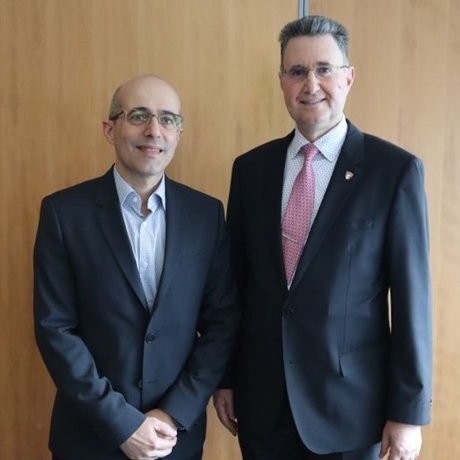 Two men in suits posing for camera