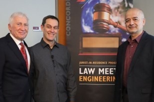 Group photo of men standing in front of a "Law Meets Engineering" poster while posing