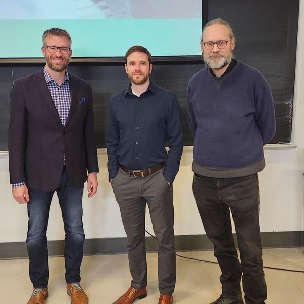 Group of photo standing in front of a chalkboard with a projector screen