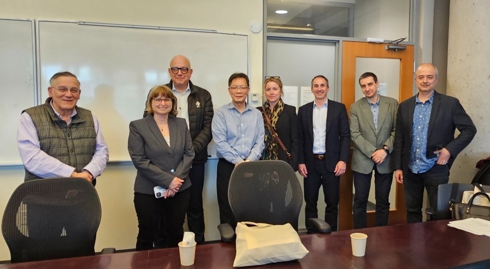 Group photo of people standing in a conference room posing for the camera