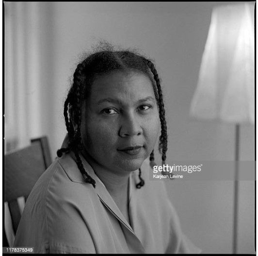 African American author and cultural critic bell hooks poses for a black and white photo.