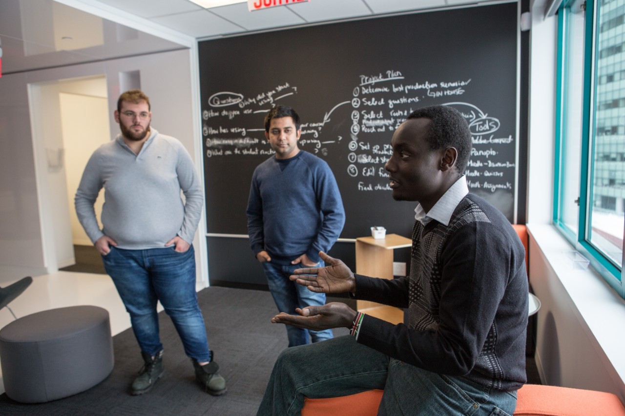 Three students in a room having a discussion