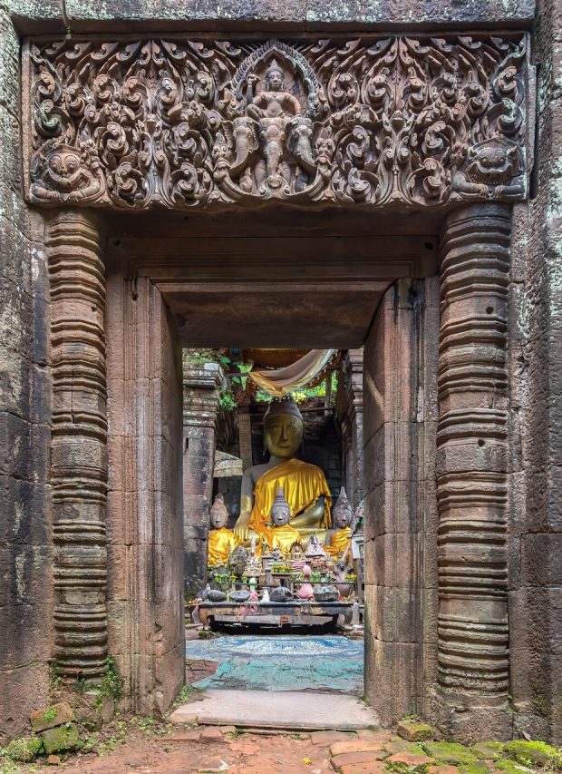 Image : Stone gate with columns and Buddhist reliefs leading to a clothed statue of the Buddha seated, Wat Phou temple, Champasak, Laos, Photo: Basile Morin. Creative Commons Attribution-Share Alike 4.0 International license