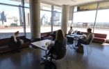 Lounge with couches, chairs and tables. Two people sitting down
