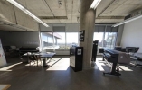 Desks lined up in a row in an semi-empty room