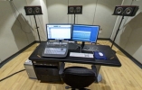 Thumbnail of mixing console and desk with computes in front of three large standing speakers