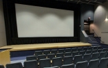 Projector room with a large screen and rows of seats in front