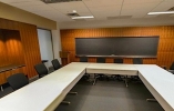 Thumbnail of a board room with donut-like rectangular desk and long television