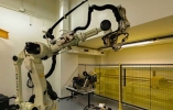 Large robotic arm in a room next to lights and shelves