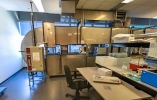 Room with a table and screens next to a large ventilation duct