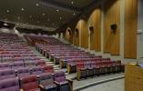 An empty auditorium from the view of the podium in front of the row seats