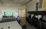 Lab filled with computer cubicles, a desk and a TV to test games